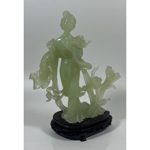 302 - A VINTAGE JADEITE JADE TYPE FIGURE ON A WOODEN DISPLAY BASE, HEIGHT 23 CM