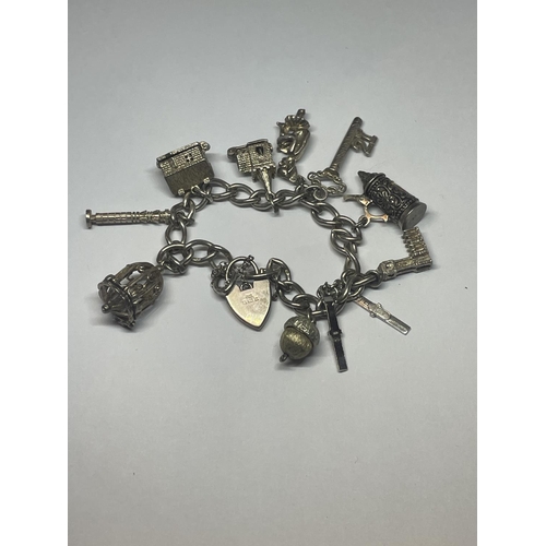 517 - A SILVER CHARM BRACELET WITH TEN CHARMS