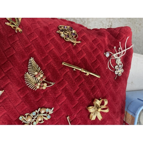 965A - A CUSHION WITH A LARGE COLLECTION OF COSTUME JEWELLERY BROOCHES