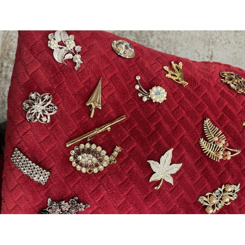 965A - A CUSHION WITH A LARGE COLLECTION OF COSTUME JEWELLERY BROOCHES