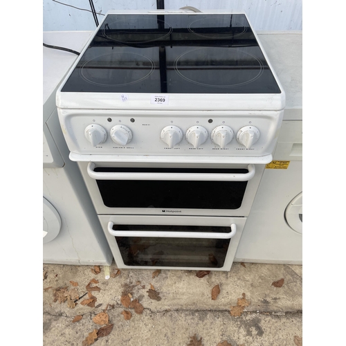 2369 - A BLACK AND WHITE HOTPOINT ELECTRIC FREESTANDING OVEN AND HOB