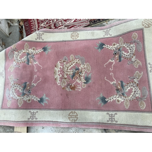 2495 - A PINK PATTERNED FRINGED RUG AND A SMALL RED PATTERNED RUG