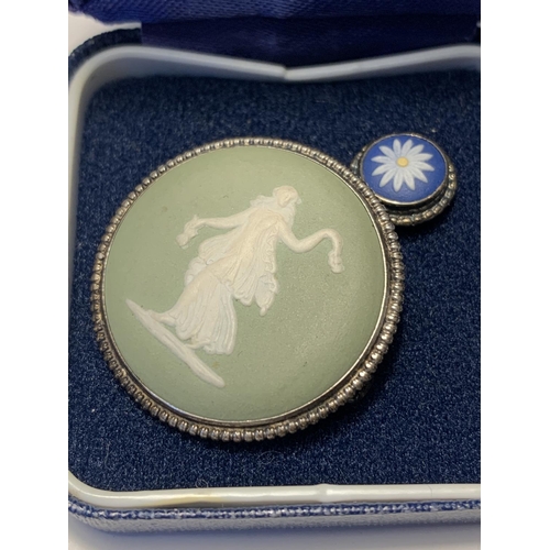 556 - A GREEN WEDGWOOD BROOCH AND TRI COLOUR FLOWER DESIGN STUD IN A PRESENTATION  BOX