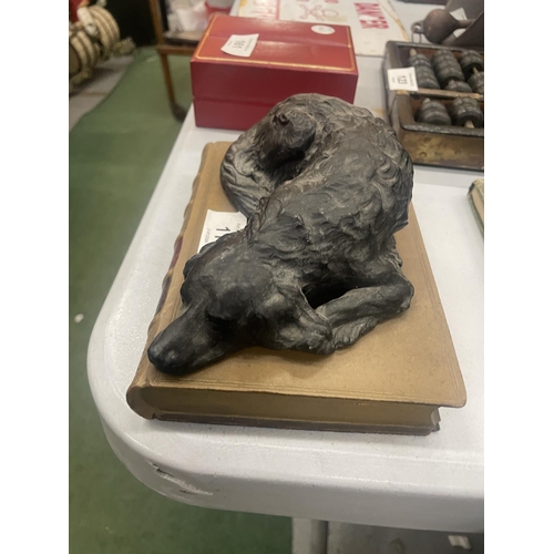 119 - A HEAVY MODEL OF A SLEEPING DOG ON A STONEWARE BOOK, LENGTH 18CM, HEIGHT 7CM