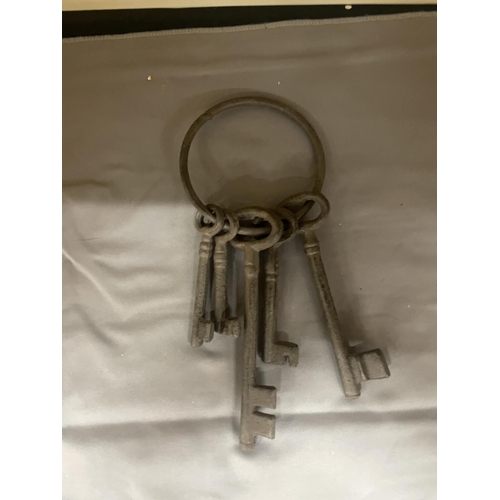 135 - A SET OF FIVE LARGE CAST KEYS ON A LARGE RING