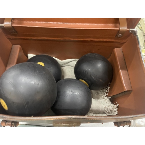 152 - FOUR IDENTICAL BOWLING BOWLS, NUMBERED 1, 2, 3 AND 4 IN A VINTAGE LEATHER CASE