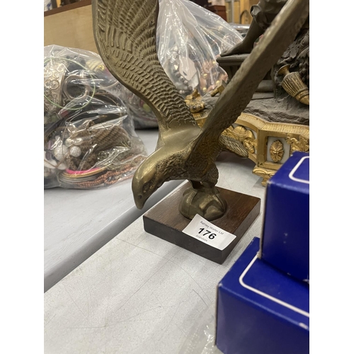 176 - A HEAVY BRASS MODEL OF AN EAGLE ON A WOODEN PLINTH, HEIGHT 24CM