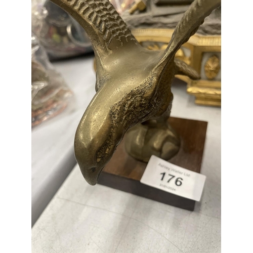 176 - A HEAVY BRASS MODEL OF AN EAGLE ON A WOODEN PLINTH, HEIGHT 24CM