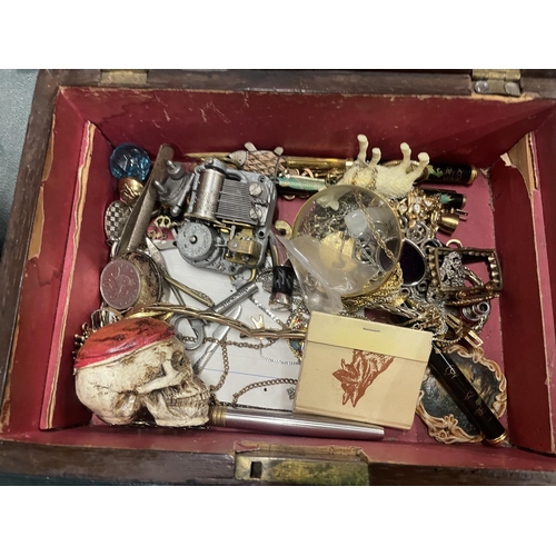 202 - A VINTAGE WOODEN BOX CONTAINING A QUANTITY OF COLLECTABLE ITEMS TO INCLUDE A SKULL, PENS, COSTUME JE... 