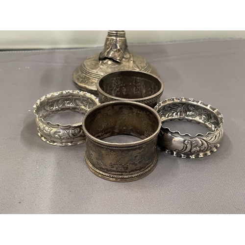 23 - FIVE VARIOUS ITEMS OF MARKED SILVER TO INCLUDE NAPKIN RINGS AND A WEIGHTED CANDLESTICK (A/F) GROSS W... 