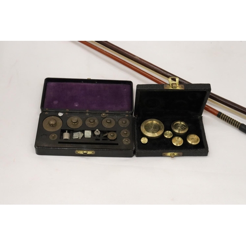 262 - TWO VINTAGE BOXED SETS OF WEIGHTS PLUS A VIOLIN BOW AND A SWAGGER STICK