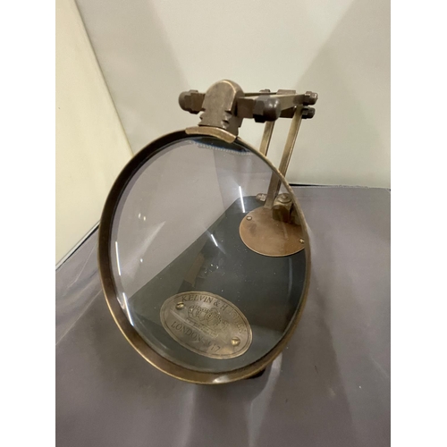 35 - A BRASS MAGNIFYING GLASS ON A WOODEN BASE