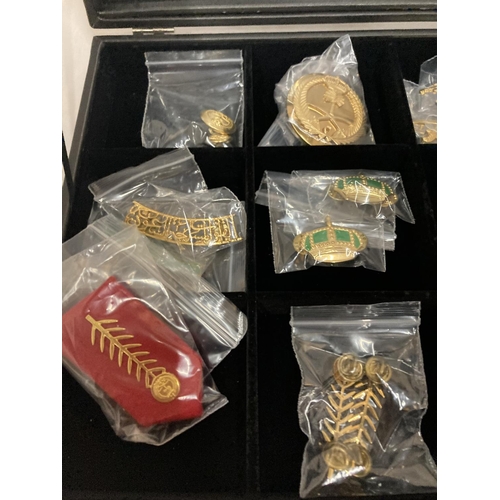 392 - A DISPLAY CASE CONSTAINING TWENTY FIVE GULF MEDALS AND BADGES INCLUDING A PAIR OF SAUDI ARMY EPAULET... 