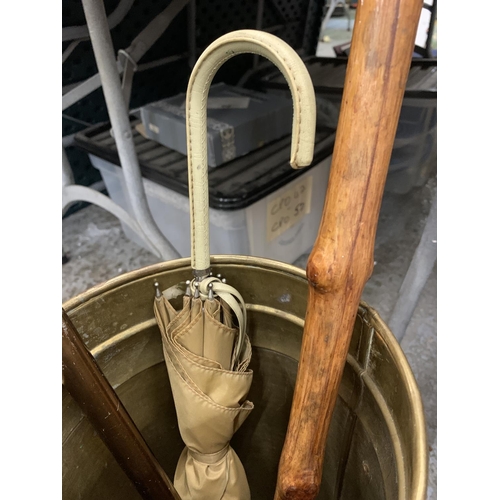 762 - A VINTAGE BRASS STICK/UMBRELLA STAND WITH LION HANDLES, A SHOOTING STICK AND ELEPHANT HEADED WALKING... 