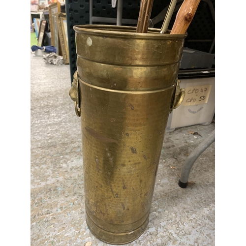 762 - A VINTAGE BRASS STICK/UMBRELLA STAND WITH LION HANDLES, A SHOOTING STICK AND ELEPHANT HEADED WALKING... 