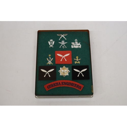 402 - A CASED COLLECTION OF GURKHA BADGES