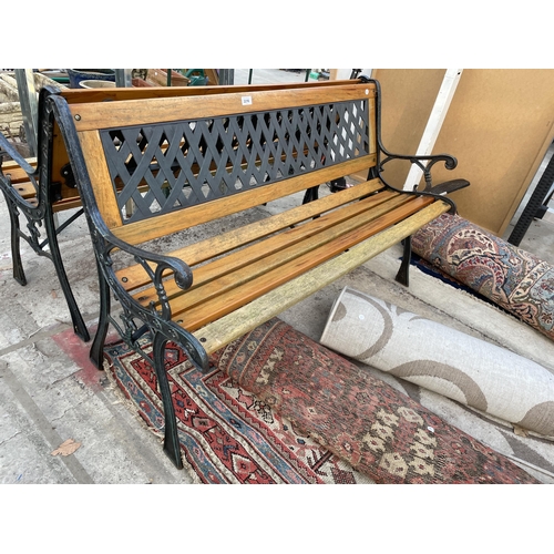 2216 - A WOODEN SLATTED GARDEN BENCH WITH CAST BENCH ENDS AND PLASTIC BACK