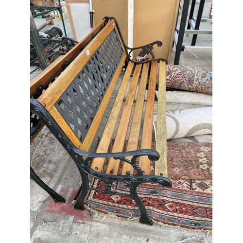 2216 - A WOODEN SLATTED GARDEN BENCH WITH CAST BENCH ENDS AND PLASTIC BACK