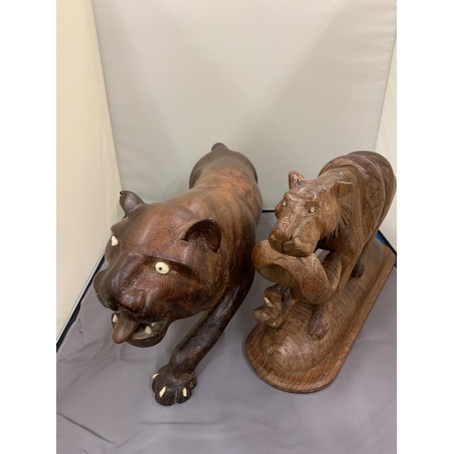 42 - TWO TREEN CARVINGS OF WILD CATS ONE WITH A SNAKE AS PRAY