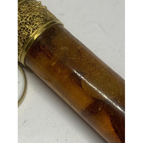 667 - AN AMBER CHEROOT HOLDER WITH A DECORATIVE TESTED TO 9 CARAT GOLD COLLAR