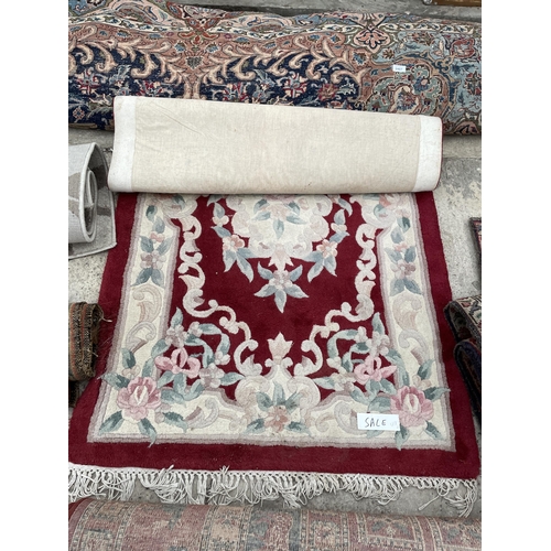 2488 - A SMALL RED PATTERNED FRINGED RUG