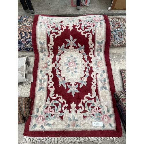 2488 - A SMALL RED PATTERNED FRINGED RUG