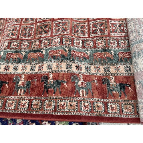 2489 - A RED PATTERNED RUG DEPICTING VARIOUS ANIMALS