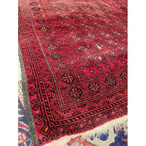 2490 - A SMALL RED PATTERNED FRINGED RUG