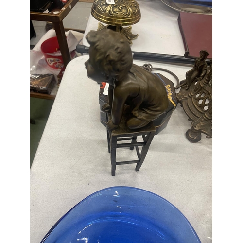 130 - A BRONZE MODEL OF A CHILD KNEELING ON A STOOL SIGNED