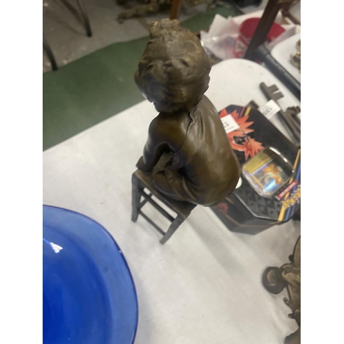 130 - A BRONZE MODEL OF A CHILD KNEELING ON A STOOL SIGNED