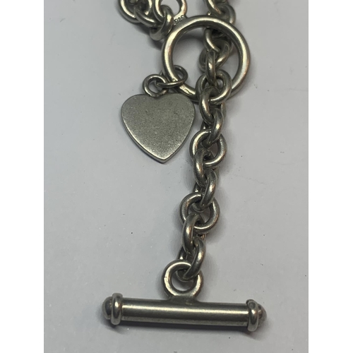 688 - A SILVER T BAR BRACELET WITH HEART CHARM