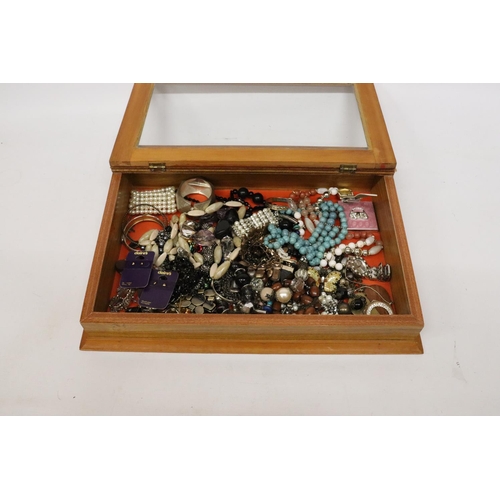 832 - A QUANTITY OF COSTUME JEWELLERY IN A GLASS TOPPED DISPLAY CASE