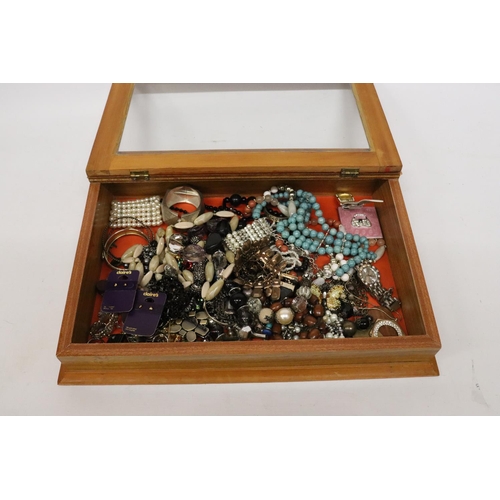 832 - A QUANTITY OF COSTUME JEWELLERY IN A GLASS TOPPED DISPLAY CASE