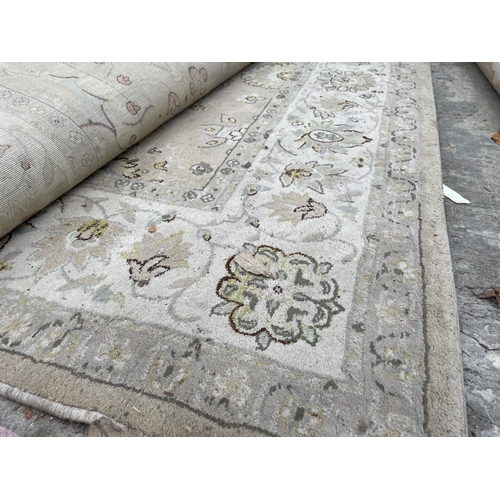 2500 - A LARGE CREAM PATTERNED RUG