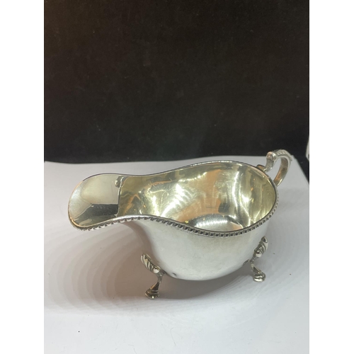 12 - A HALLMARKED BIRMINGHAM SILVER THREE LEGGED SAUCE BOAT