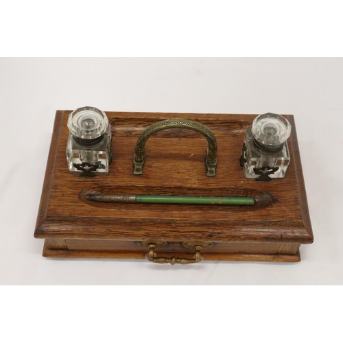 177 - A VINTAGE OAK DESKSET WITH BRASS HANDLE AND DRAWER WITH GLASS INKWELLS