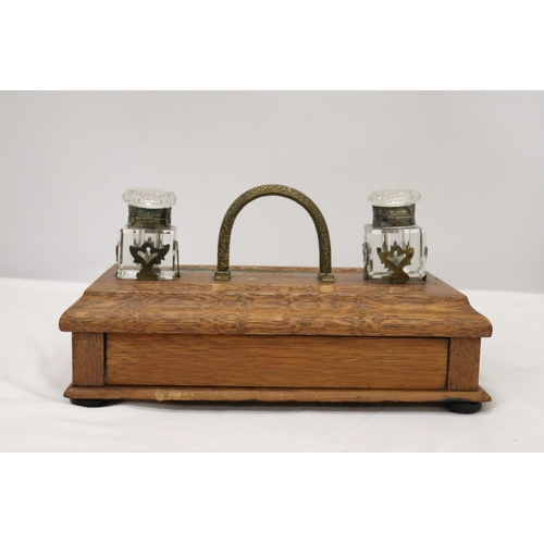 177 - A VINTAGE OAK DESKSET WITH BRASS HANDLE AND DRAWER WITH GLASS INKWELLS