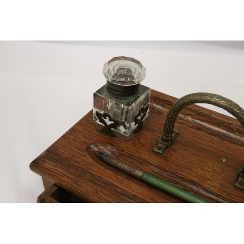 177 - A VINTAGE OAK DESKSET WITH BRASS HANDLE AND DRAWER WITH GLASS INKWELLS