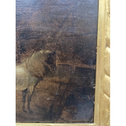 89 - A GILT FRAMED OIL ON BOARD OF A HORSE IN A STABLE