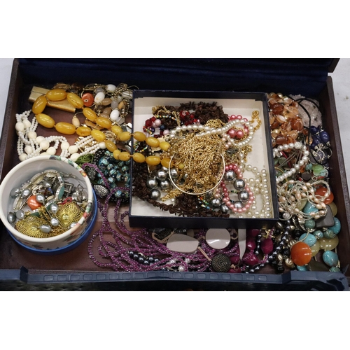 321 - A LARGE QUANTITY OF COSTUME JEWELLERY TO INCLUDE AMBER STYLE BEADS, BANGLES, NECKLACES, BEADS, ETC, ... 