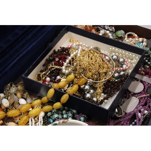 321 - A LARGE QUANTITY OF COSTUME JEWELLERY TO INCLUDE AMBER STYLE BEADS, BANGLES, NECKLACES, BEADS, ETC, ... 