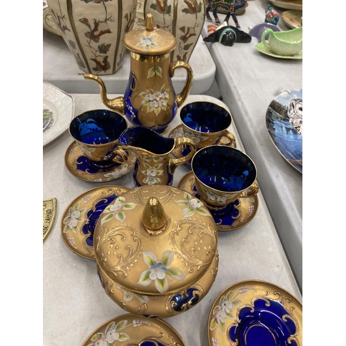 335 - A COLLECTION OF BOHEMIAN BLUE GLASSWARE WITH GILT AND FLORAL PATTERN TO INCLUDE A SMALL COFFEE POT, ... 