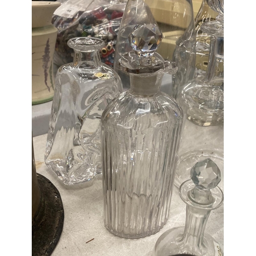 142 - A QUANTITY OF GLASS BOTTLES SOME WITH STOPPERS AND DECANTERS