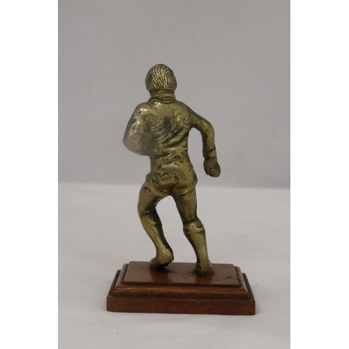 191 - A VINTAGE BRASS RUGBY PLAYER ON A WOODEN PLINTH