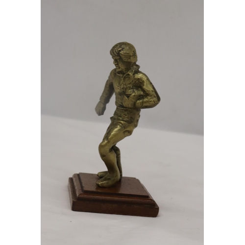 191 - A VINTAGE BRASS RUGBY PLAYER ON A WOODEN PLINTH