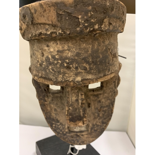 19 - A LATE 19TH CENTURY EARLY 20TH CENTURY MALI DOGON MASK ON A MUSEUM STYLE STAND