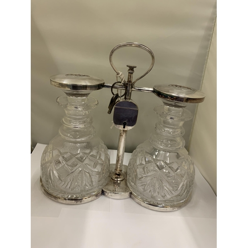 3 - A WHITE METAL TANTALUS WITH TWO CUT GLASS DECANTERS WITH PADLOCK AND KEY