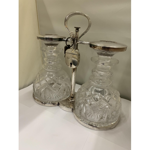 3 - A WHITE METAL TANTALUS WITH TWO CUT GLASS DECANTERS WITH PADLOCK AND KEY