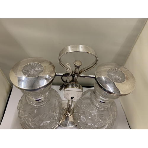 3 - A WHITE METAL TANTALUS WITH TWO CUT GLASS DECANTERS WITH PADLOCK AND KEY