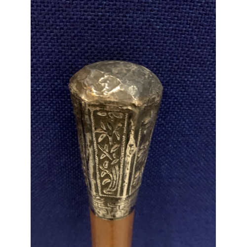 71 - A WALKING STICK WITH A POSSIBLY CONTINENTAL SILVER ORNATE TOP